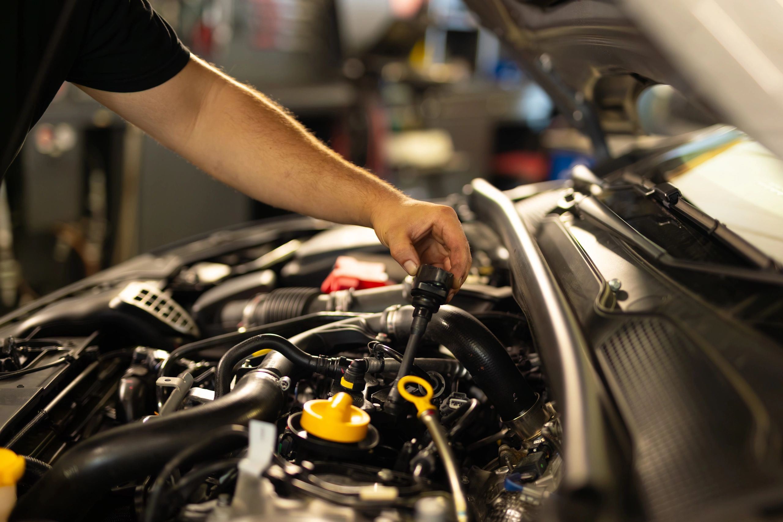 Mechanic checking engine oil during vehicle maintenance
